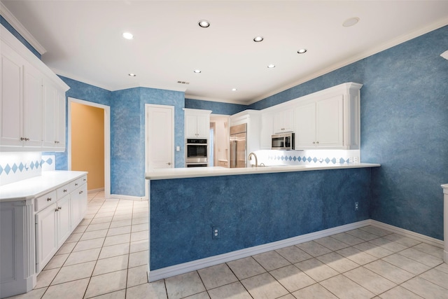 kitchen featuring stainless steel appliances, white cabinetry, and kitchen peninsula