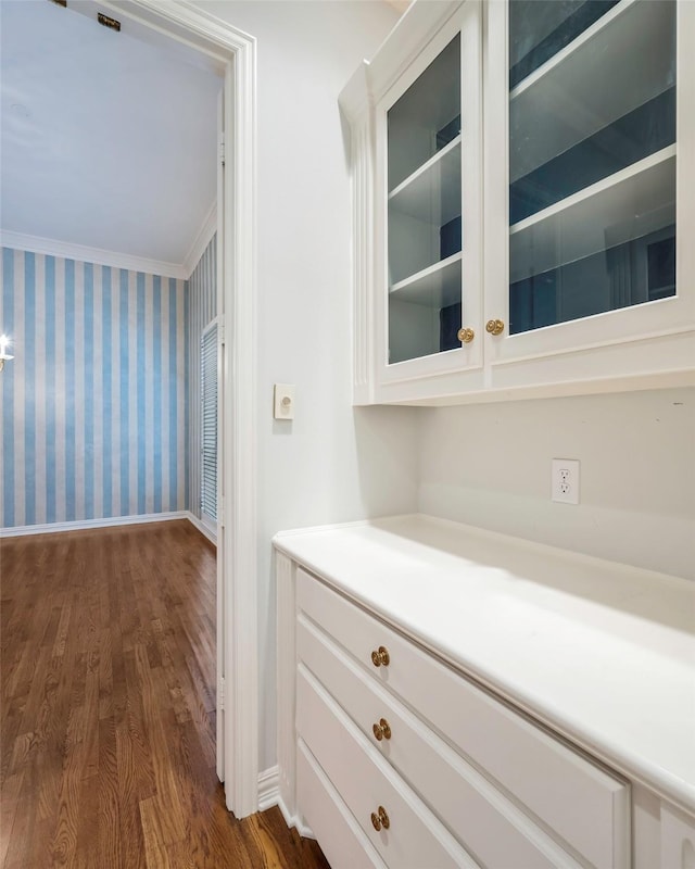 hallway with dark hardwood / wood-style flooring and crown molding