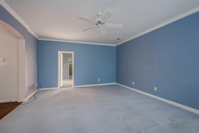 empty room featuring crown molding, ceiling fan, and carpet