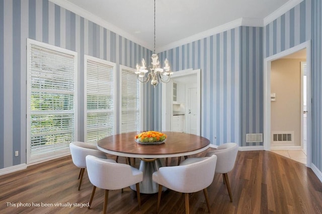 dining room featuring hardwood / wood-style flooring, crown molding, and a notable chandelier