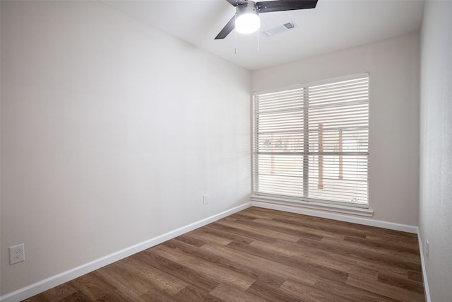 spare room with dark wood-type flooring and ceiling fan