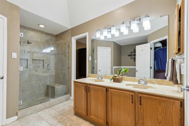 bathroom featuring walk in shower, vanity, and tile patterned flooring