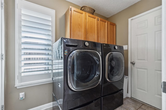 washroom with cabinets, light tile patterned floors, independent washer and dryer, and a textured ceiling