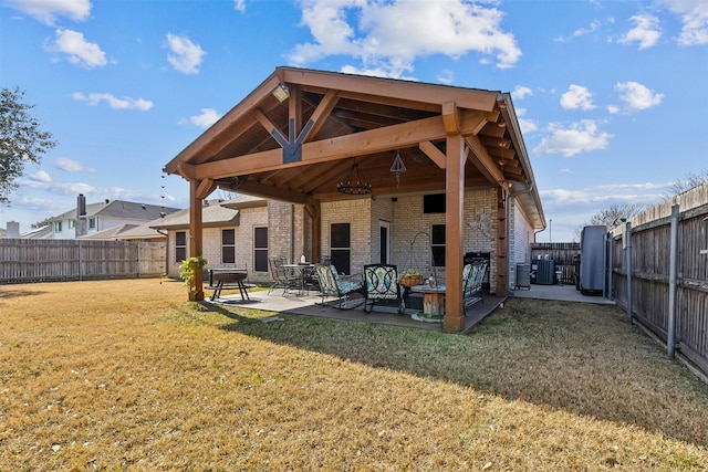 rear view of property featuring a patio, a yard, and central AC unit