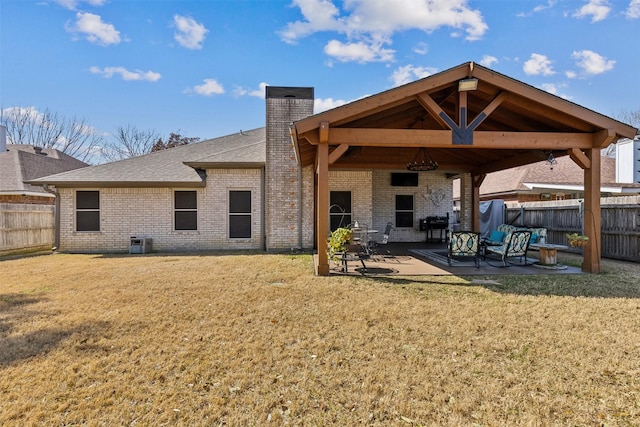 rear view of house featuring central AC unit, a patio area, and a lawn