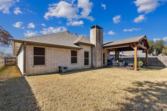 rear view of house with a lawn and a patio area