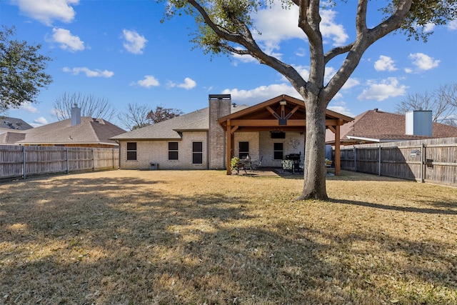 rear view of house with a patio and a lawn