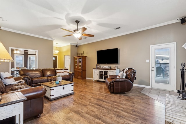 living room featuring wood-type flooring, ornamental molding, and ceiling fan