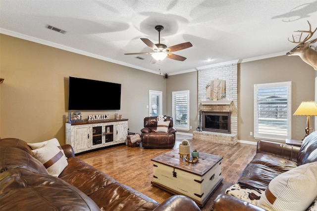 living room with crown molding, a healthy amount of sunlight, and light wood-type flooring