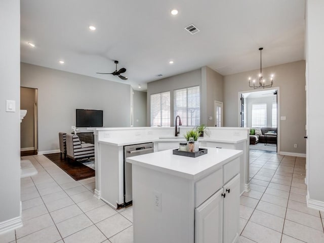 kitchen featuring ceiling fan with notable chandelier, a kitchen island, visible vents, open floor plan, and stainless steel dishwasher