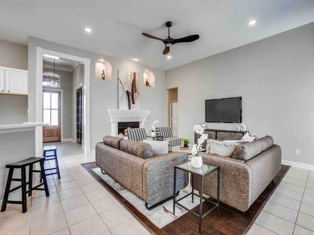 living room with light tile patterned floors, recessed lighting, a fireplace, and baseboards