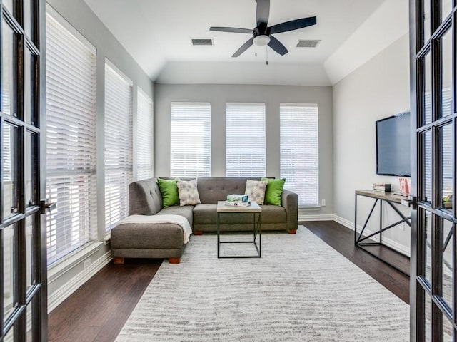 living room with dark wood-style floors, baseboards, and visible vents