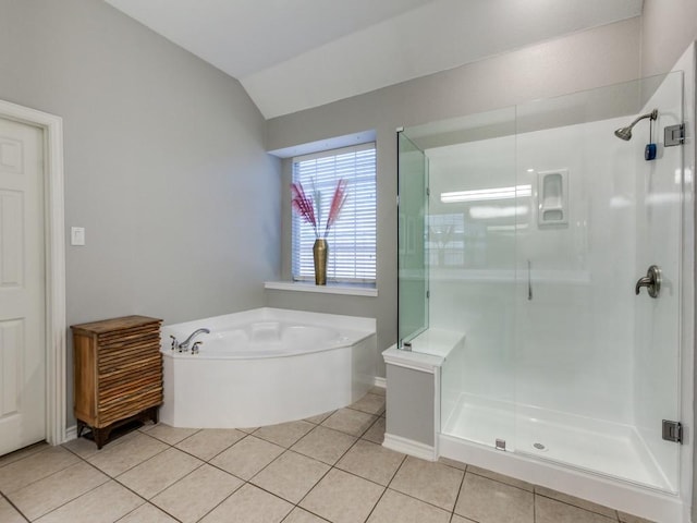 bathroom featuring a garden tub, lofted ceiling, a stall shower, tile patterned flooring, and baseboards