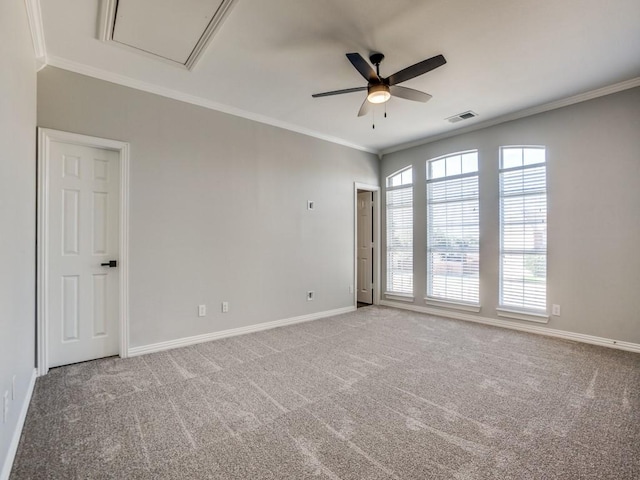 carpeted spare room featuring a ceiling fan, visible vents, crown molding, and baseboards