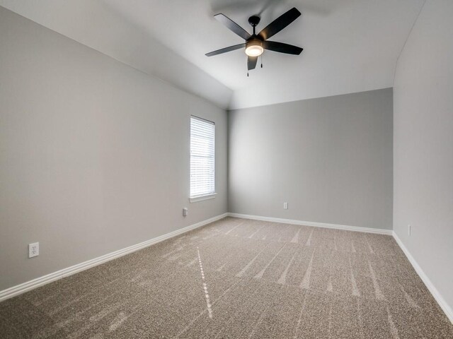 carpeted empty room with lofted ceiling