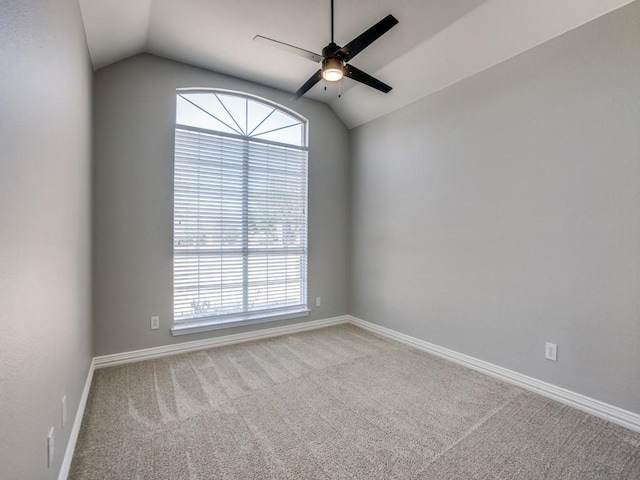 spare room with baseboards, a ceiling fan, vaulted ceiling, and carpet flooring