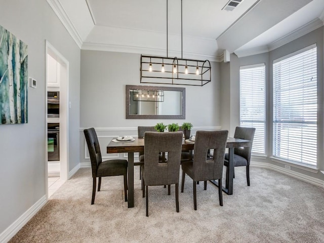 dining area featuring light carpet, a chandelier, visible vents, and crown molding