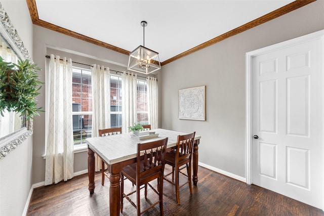 dining area featuring crown molding, dark wood-type flooring, a wealth of natural light, and a chandelier