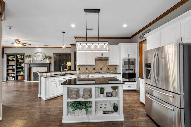 kitchen featuring pendant lighting, white cabinetry, sink, a center island, and stainless steel appliances