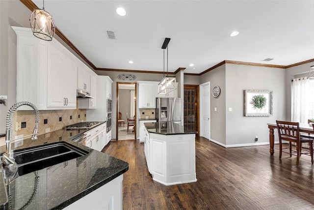 kitchen featuring stainless steel appliances, a center island, sink, and hanging light fixtures