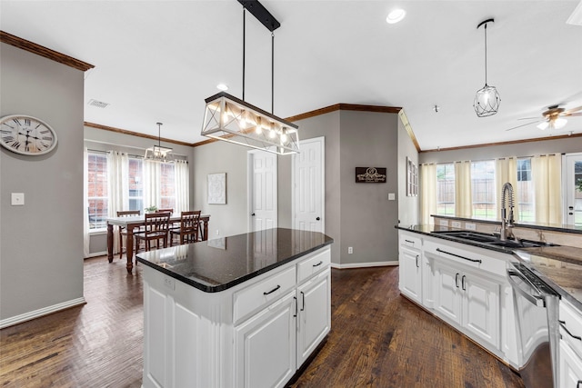 kitchen with hanging light fixtures, dishwasher, sink, and white cabinets