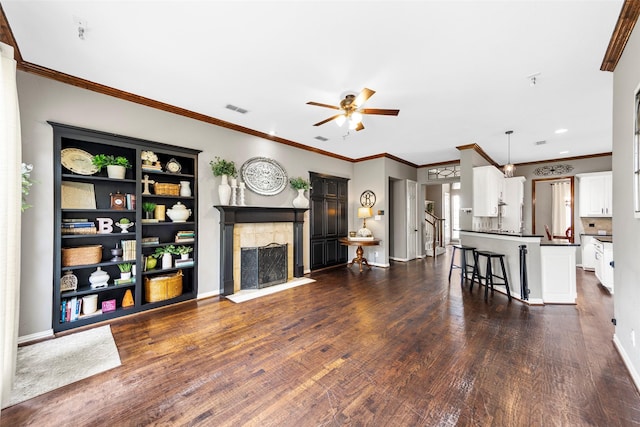 living room with ceiling fan, ornamental molding, and dark hardwood / wood-style floors