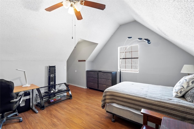 bedroom with hardwood / wood-style flooring, ceiling fan, vaulted ceiling, and a textured ceiling