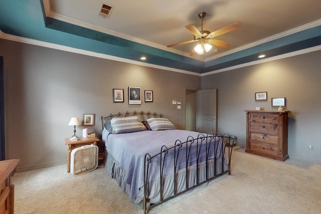 carpeted bedroom featuring a tray ceiling, ornamental molding, and ceiling fan