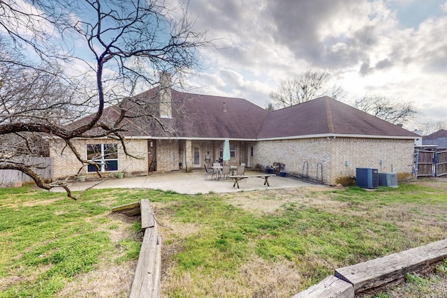 back of house featuring central AC unit, a patio area, and a lawn