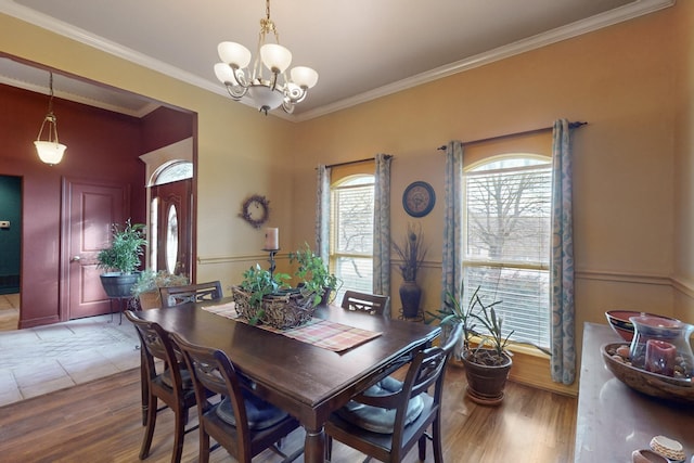 dining area featuring crown molding, hardwood / wood-style floors, and a notable chandelier