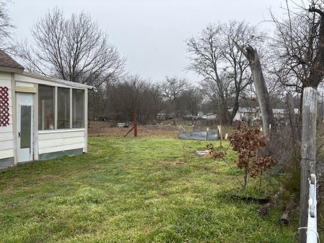 view of yard featuring a pool and a sunroom