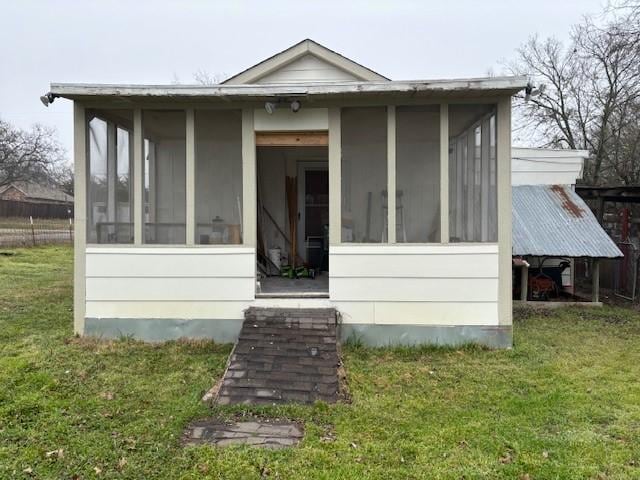 back of house with a yard and a sunroom