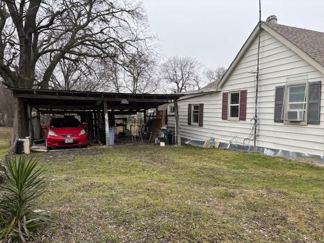 view of property exterior featuring cooling unit, a carport, and a lawn