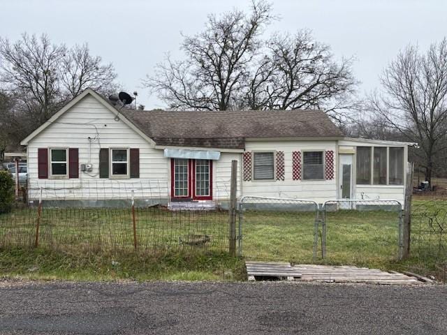 ranch-style home with a front yard and a sunroom