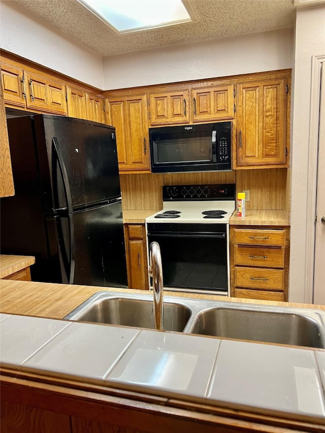 kitchen with a textured ceiling and black appliances