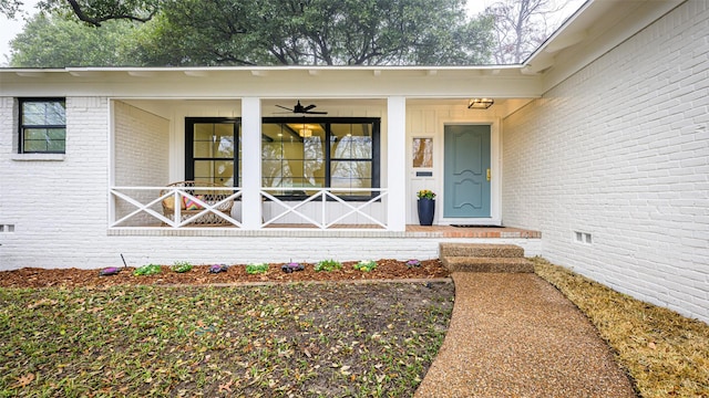 view of exterior entry featuring ceiling fan and covered porch