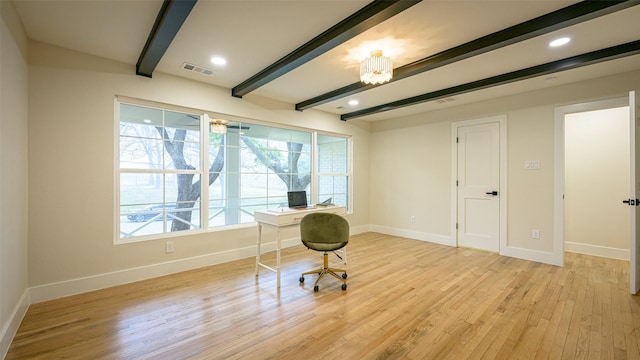 office featuring beamed ceiling, a wealth of natural light, and light hardwood / wood-style floors