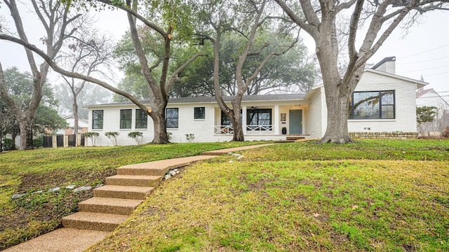 single story home with a front lawn and covered porch