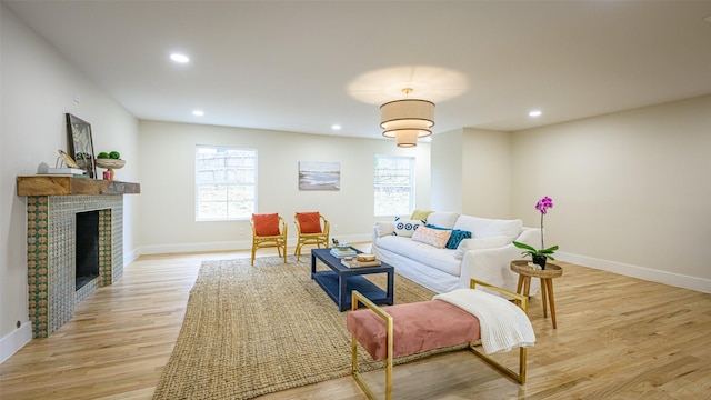 living room with light hardwood / wood-style floors and a brick fireplace