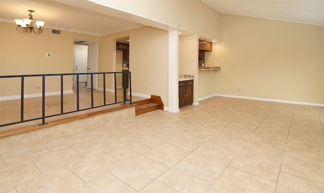 tiled empty room featuring an inviting chandelier and ornamental molding