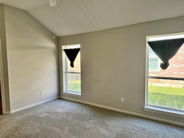 carpeted spare room with lofted ceiling