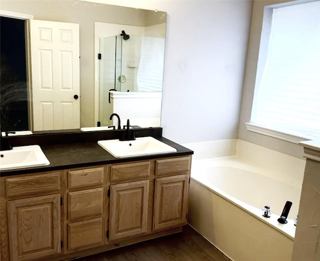 bathroom with vanity, hardwood / wood-style floors, and plus walk in shower