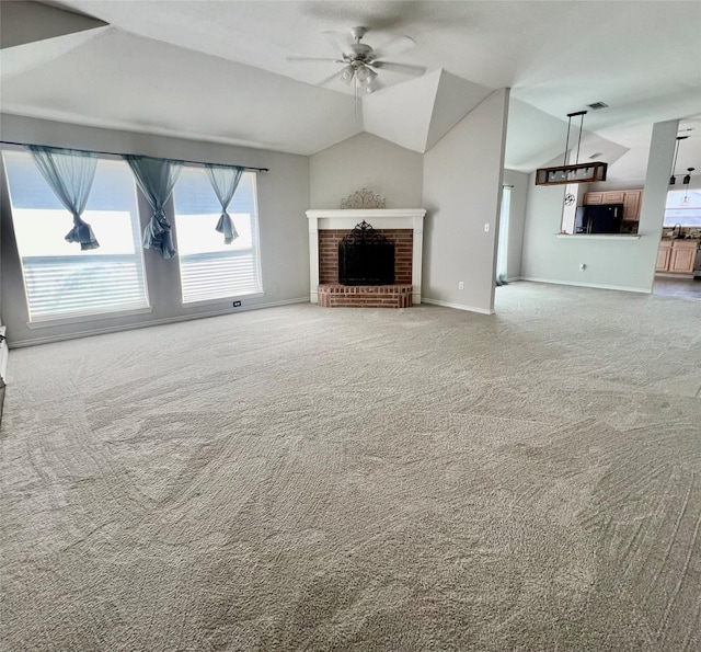 unfurnished living room with ceiling fan, lofted ceiling, carpet flooring, and a fireplace