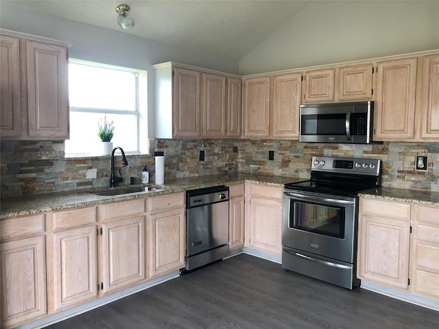 kitchen with dark wood-type flooring, lofted ceiling, sink, light stone counters, and stainless steel appliances