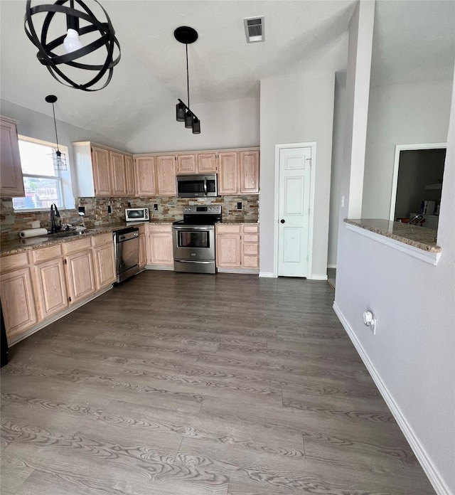 kitchen with light stone counters, decorative light fixtures, light brown cabinets, appliances with stainless steel finishes, and backsplash