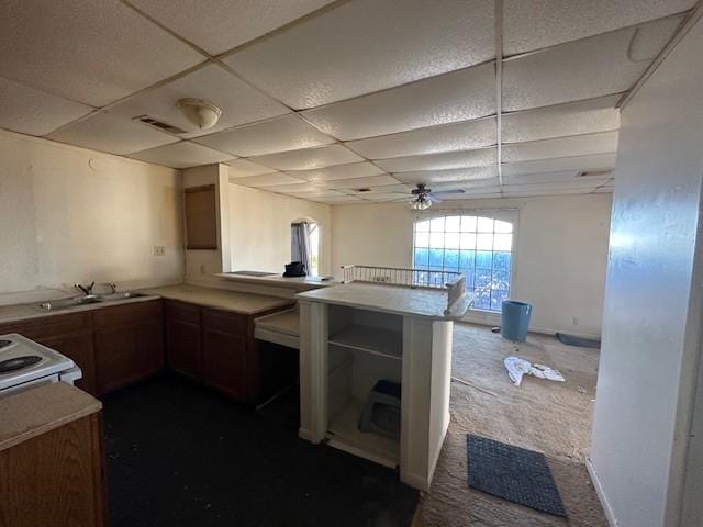 kitchen with sink, a paneled ceiling, kitchen peninsula, and ceiling fan