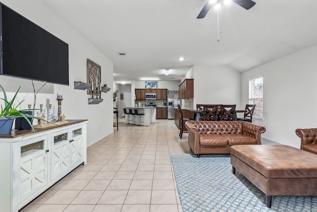 tiled living room with ceiling fan and lofted ceiling