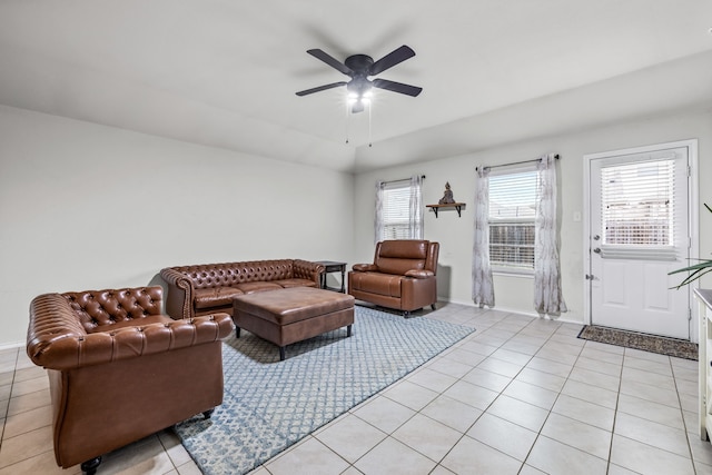 living area featuring light tile patterned floors, baseboards, and a ceiling fan