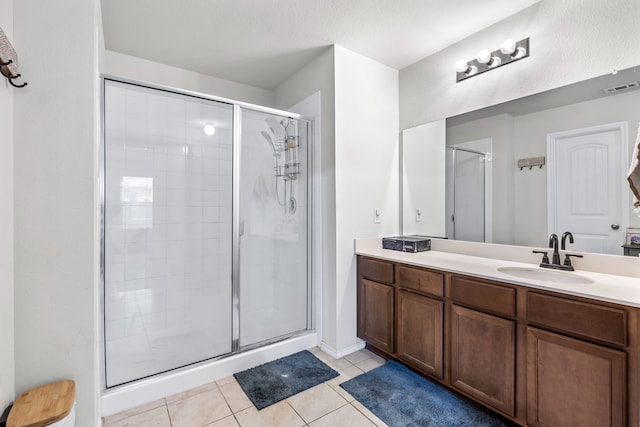 bathroom with vanity, a shower with door, and tile patterned flooring