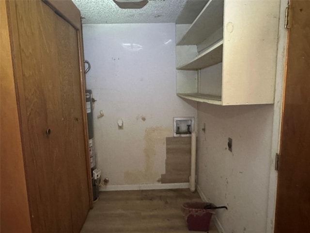 laundry area with water heater, hardwood / wood-style floors, and a textured ceiling